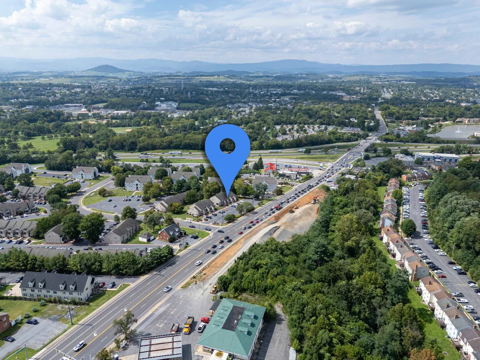 Aerial view of Camden Townes in Harrisonburg with 1319 Bradley Dr marked, showing the surrounding townhouse rows and the JMU area beyond