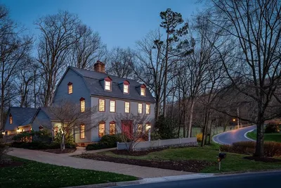Colonial home at twilight with warm interior lighting on tree-lined street in Fairway Hills, Harrisonburg VA