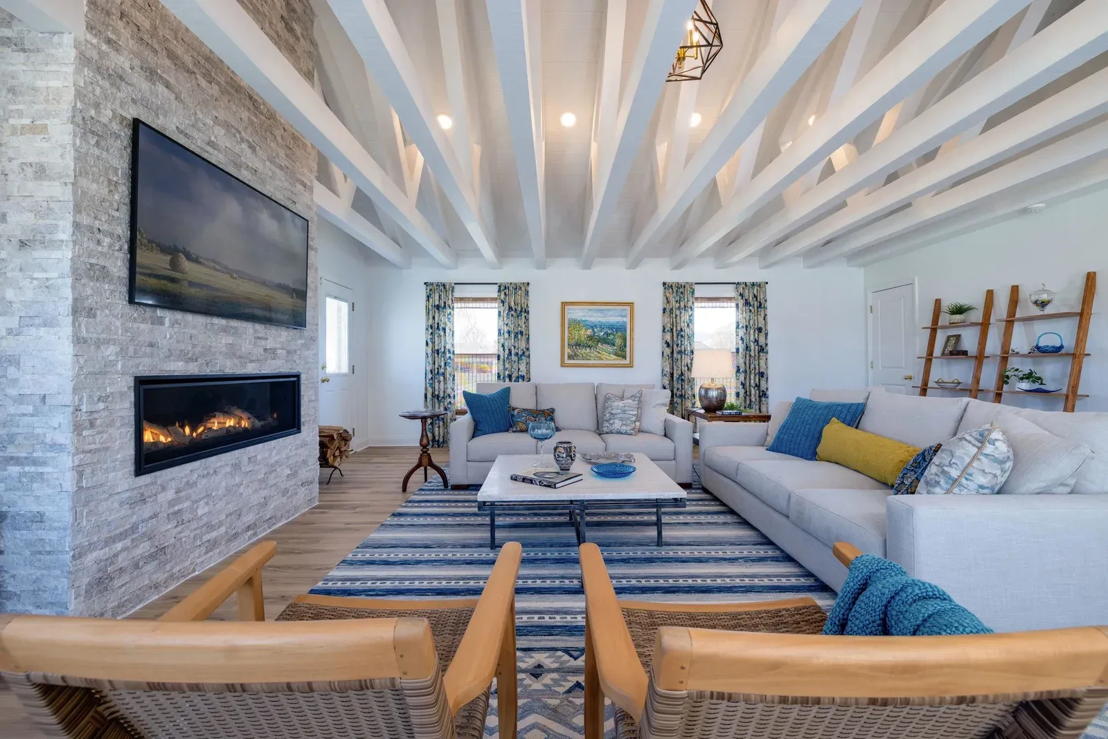 Great room at 901 Riverside Ave in Grottoes with a white beamed ceiling and a stacked-stone fireplace