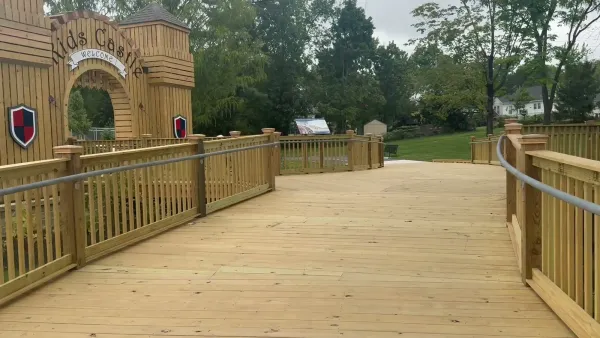 The Kids Castle entrance gate with a Welcome sign and a wooden boardwalk with handrails at Purcell Park in Harrisonburg, Virginia