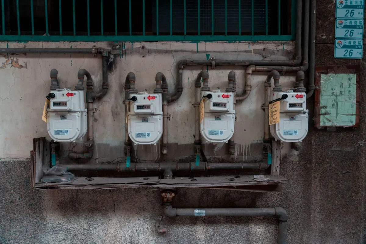 Four gas meters mounted on an exterior wall.