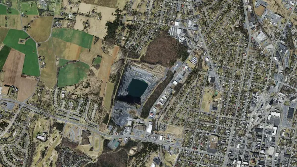 Aerial view of the Waterman Drive quarry in Harrisonburg, with the water-filled pit in the center, farmland to the west, and the Park View and downtown neighborhoods to the east