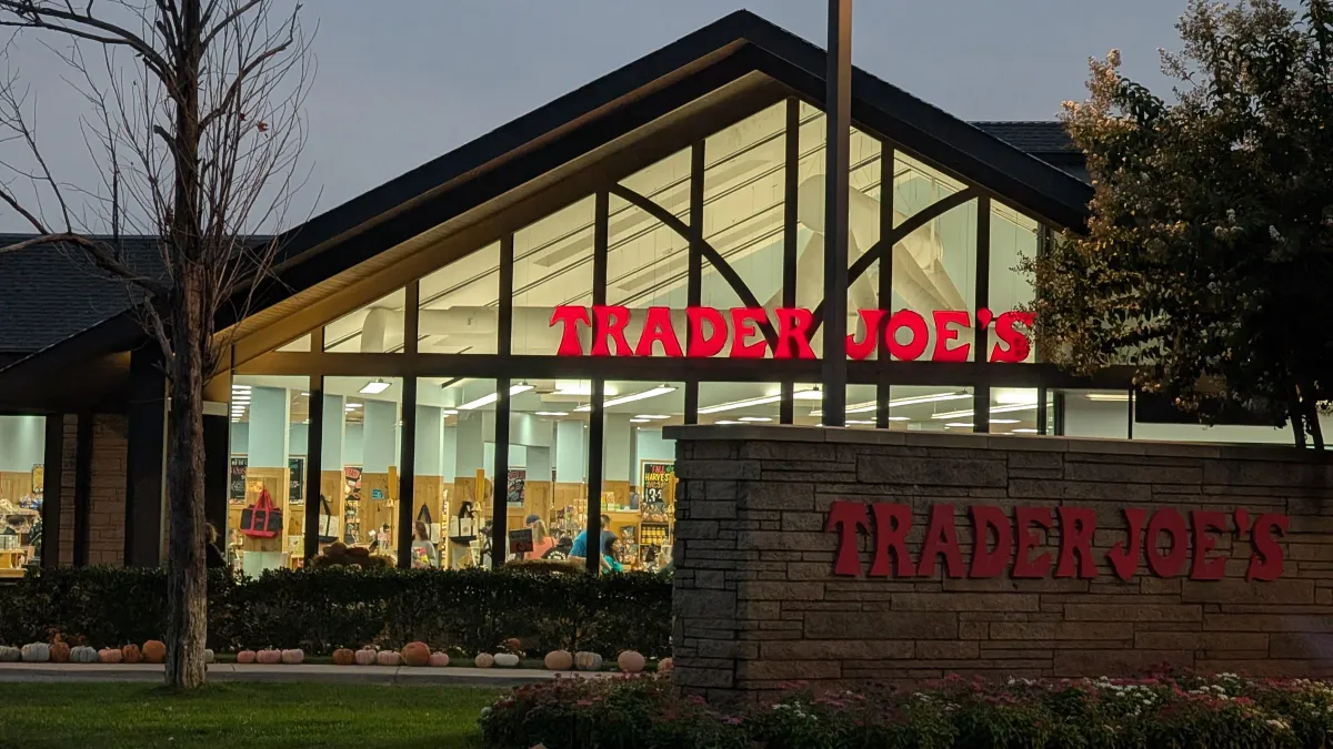 Trader Joe's storefront at dusk with a row of pumpkins out front