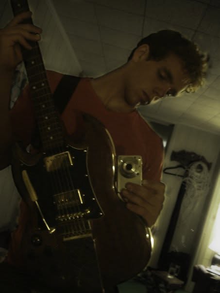 A teenage Mattias holding the guitar he built in shop class