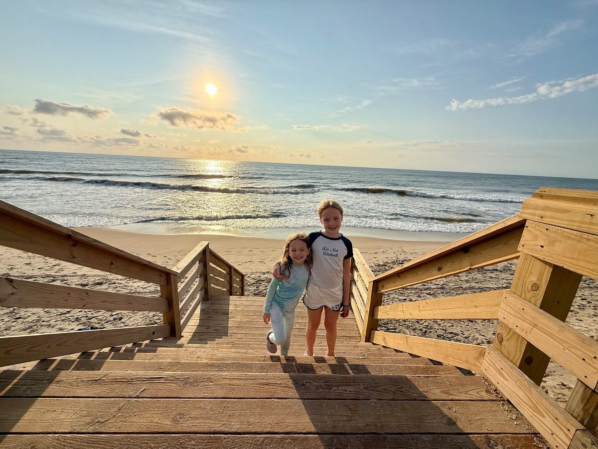 The girls at the top of the beach stairs at sunrise